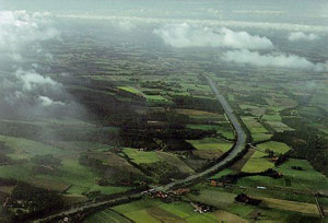 Luftbild der Kalkrieser-Niewedder Senke vom 22.10.1991. Blick von Osten. Links der Kalkrieser Berg, am Fuß des Berges die B 218 und am rechten Bildrand die Alte Heerstraße. - NLVwA-Institut für Denkmalpflege Hannover. Aufnahme: Otto Braasch; Archivnr.: 3514/004-1; 1141,3.